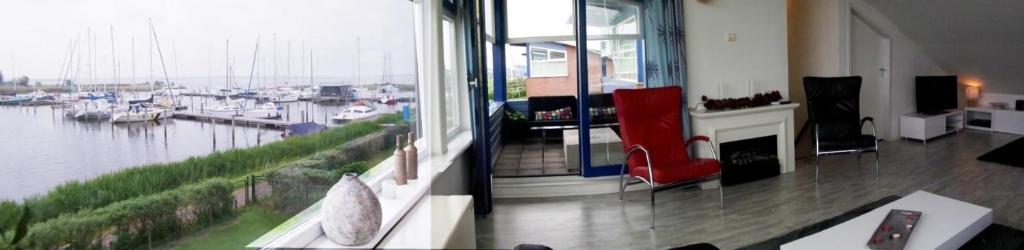 a living room with a view of a marina at Ferienhaus Jasmijn mit Garten und Terrasse in Anjum