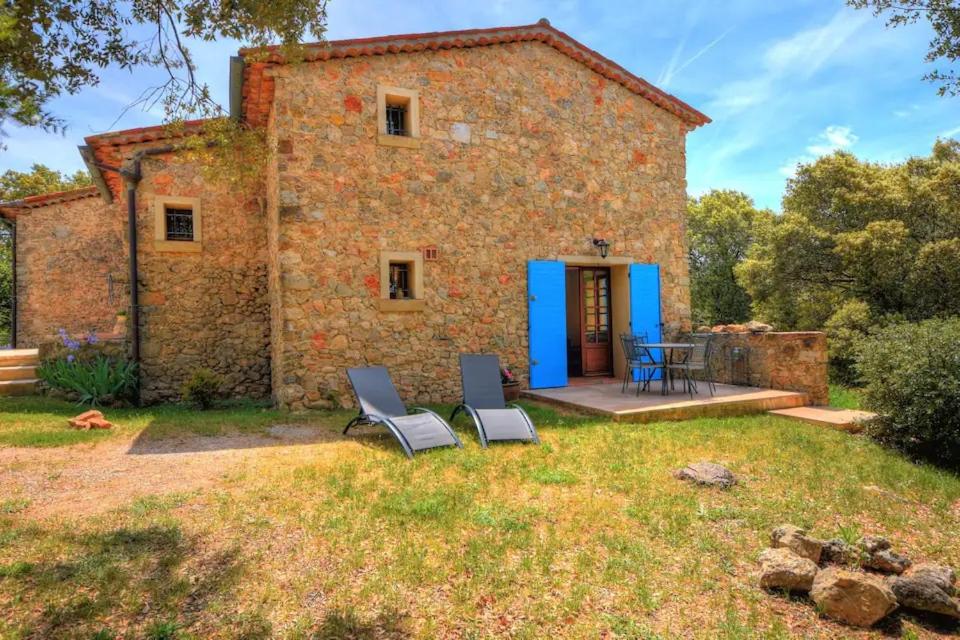 - une vue extérieure sur une maison en pierre avec 2 chaises dans l'établissement Le RAVAS, à Aups