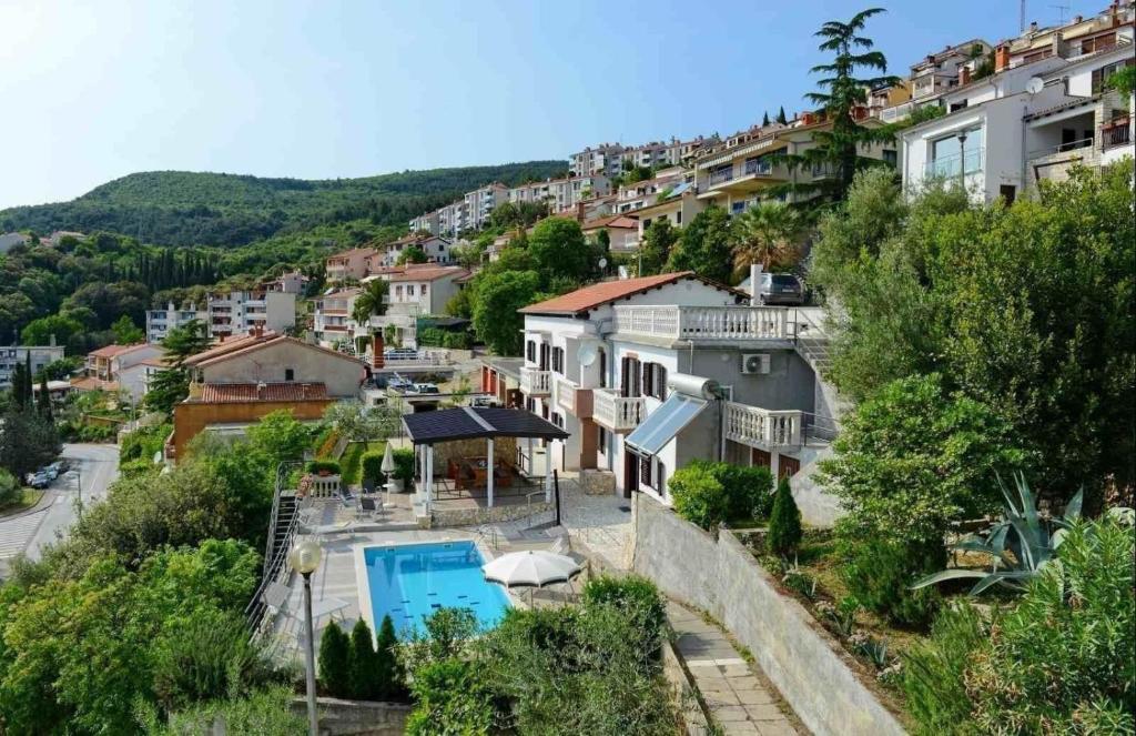 a house with a swimming pool on a hill at Ferienhaus 'Villa Ivisa' mit eigenem Pool in Rabac