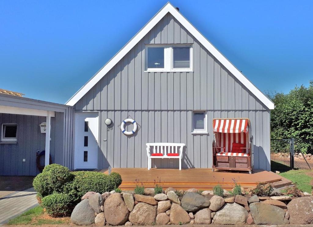 deux chaises assises sur une terrasse devant une maison dans l'établissement Ferienhaus mit Grill und Garten in Neukirchen, à Neukirchen