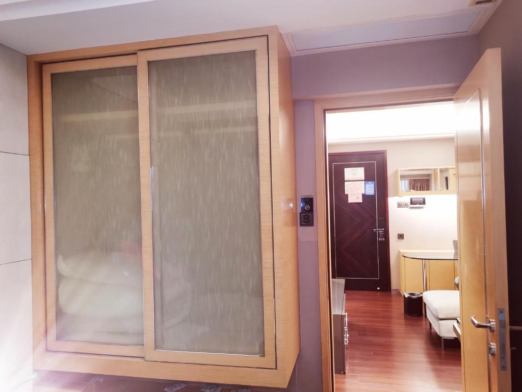 a large glass cabinet in a room with a hallway at Shenzhen Binhe Impression Hotel Apartments in Shenzhen