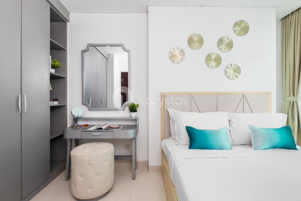a bedroom with a bed and a desk and a mirror at Azura by Kozystay - Alam Sutera in South Tangerang