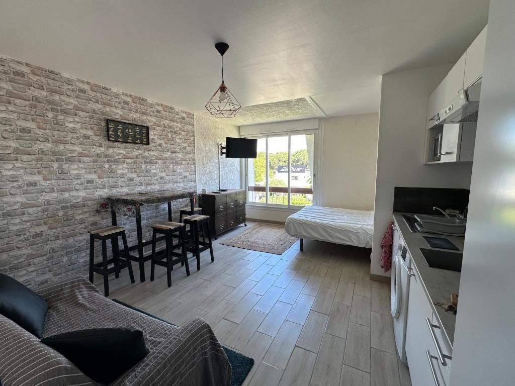 une cuisine et un salon avec une table et des chaises dans l'établissement Studio centre-ville a quelque pas de la plage - WIFI, à La Grande Motte