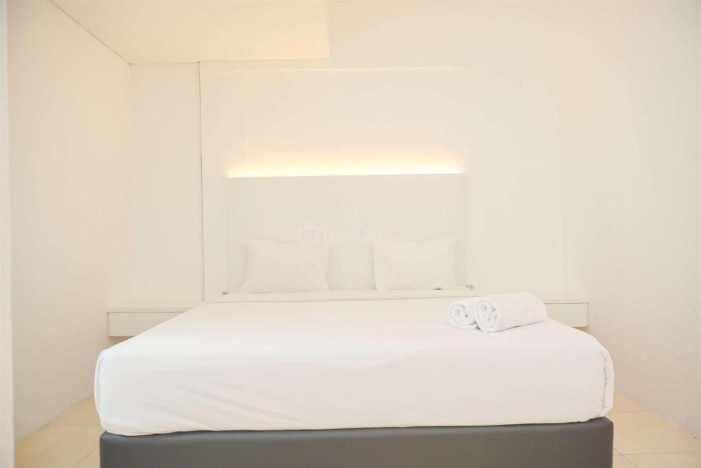 Una cama blanca con dos toallas encima. en Modern and Homey 2BR at MT Haryono Square Apartment By Travelio, en Yakarta