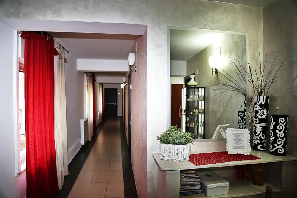 una camera con tenda rossa e corridoio di Hotel Miramonti a Gangi
