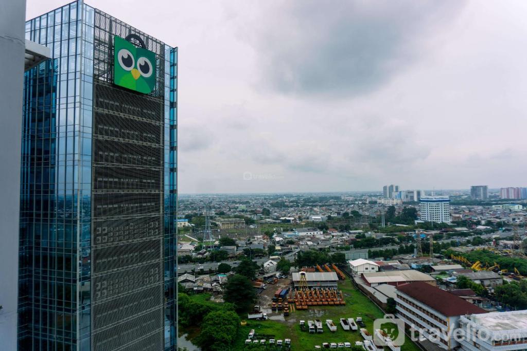 a building with the oeyes sign on the side of it at Modern Look 1BR at 22nd Floor Ciputra International Apartment By Travelio in Jakarta