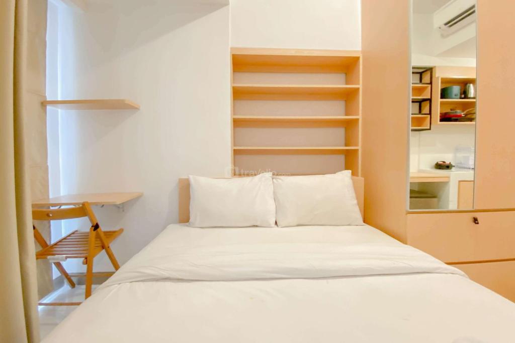 ein Schlafzimmer mit einem Bett, einem Schreibtisch und Regalen in der Unterkunft Cozy Studio Apartment Tokyo Riverside PIK 2 By Travelio in Rawalembang