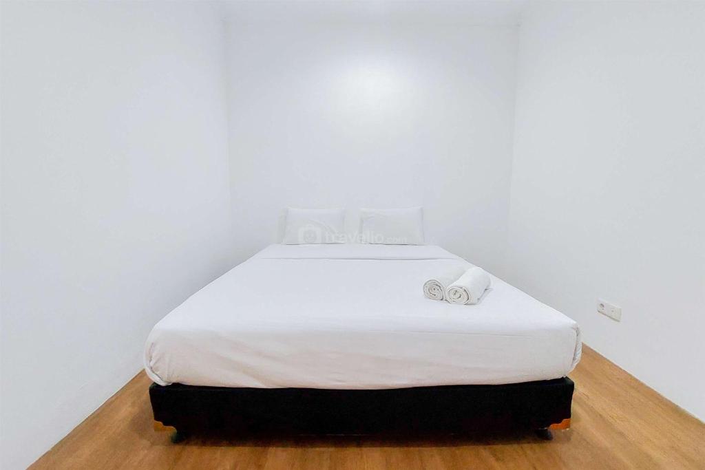a white bed with two towels on top of it at Comfy and Modern Look 2BR Asatti Apartment By Travelio in Tangerang