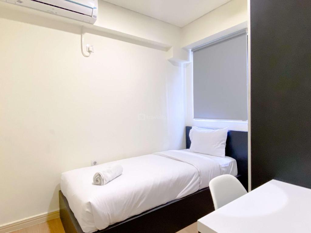 Ένα ή περισσότερα κρεβάτια σε δωμάτιο στο Comfort 2BR with Work Space at Meikarta Apartment By Travelio