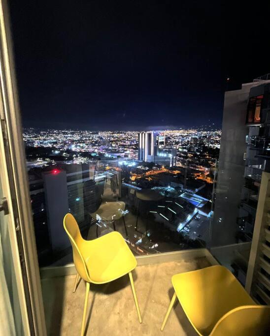 a room with two chairs and a view of a city at Studio Sabana Secrt 3011 in San José