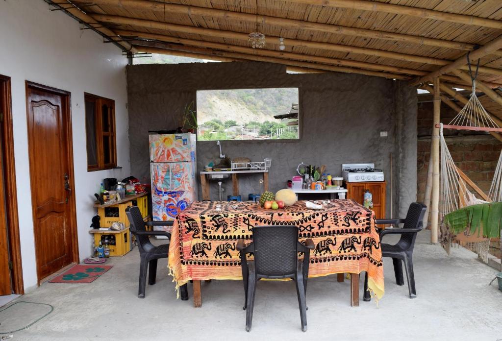 einen Esstisch mit Stühlen und einem Tischtuch in der Unterkunft Casa de Heidi in Puerto López