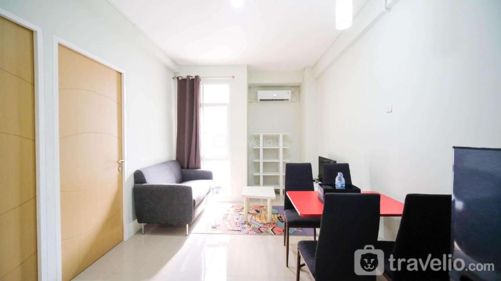a living room with a table and chairs at Best Choice and Cozy Living at 2BR at Bale Hinggil Apartment By Travelio in Medokanayu