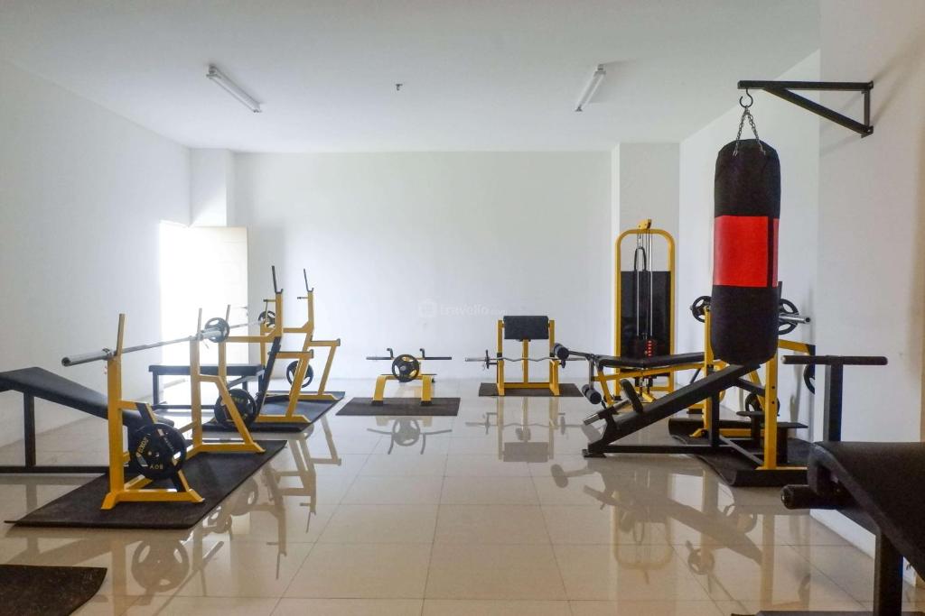 a gym with many exercise equipment in a room at Tidy and Comfy Studio at Bale Hinggil Apartment By Travelio in Medokanayu
