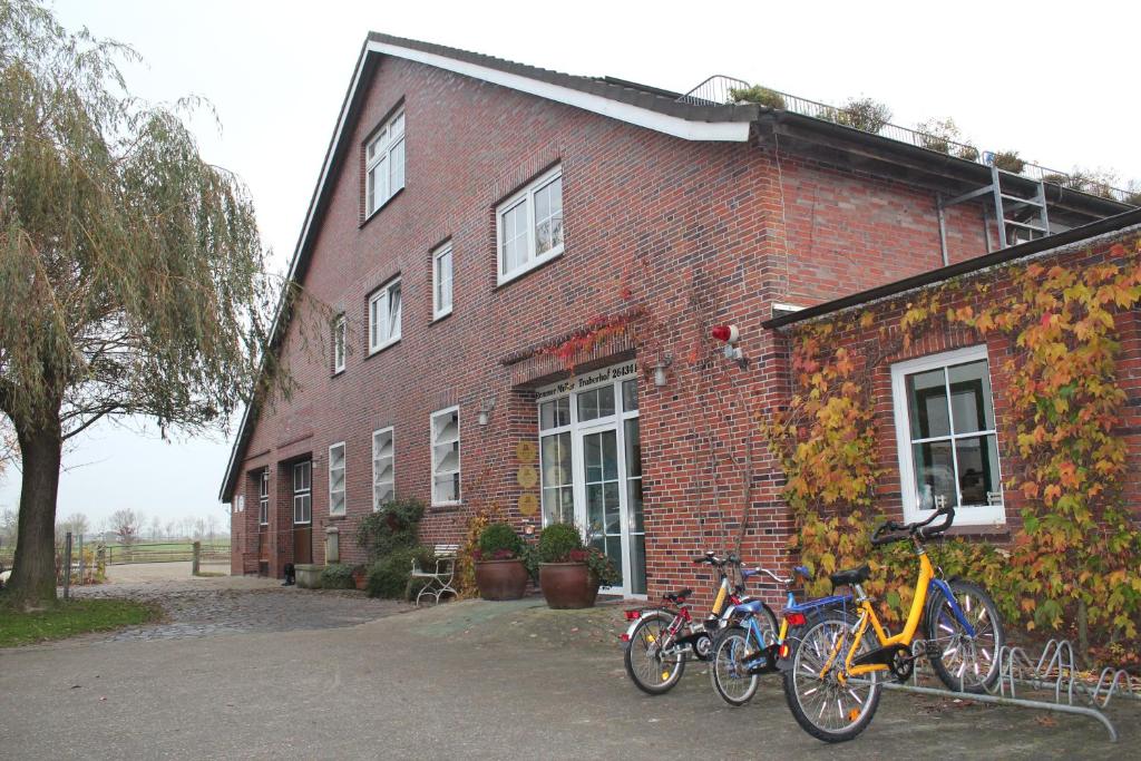 um grupo de bicicletas estacionadas fora de um edifício de tijolos em Traberhof em Wangerland