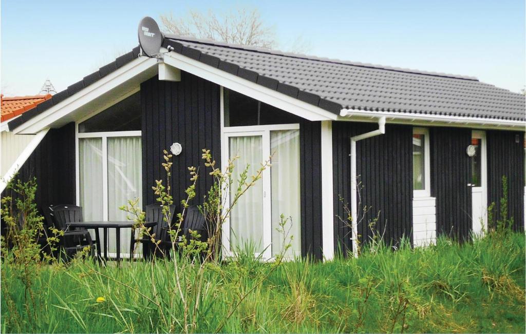 a black and white house with a chair in front of it at Dünenpark 1C - Dorf 4 in Travemünde