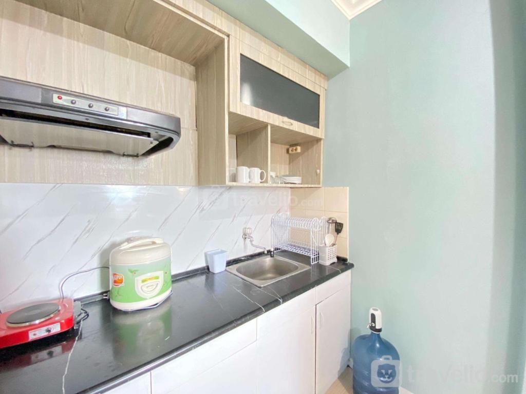 a kitchen with a sink and a counter top at Cozy Furnished 3BR at Grand Setiabudi Apartment By Travelio in Bandung