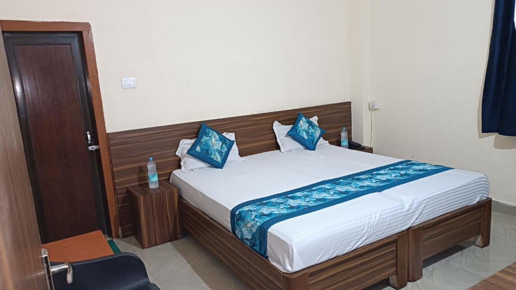 a bedroom with a large bed with blue pillows at GB Guest House By ROH in Guwahati