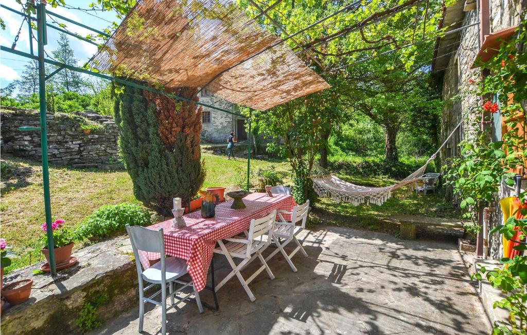 patio ze stołem i krzesłami w ogrodzie w obiekcie Beautiful Home In Badia Tedalda w mieście Badia Tedalda
