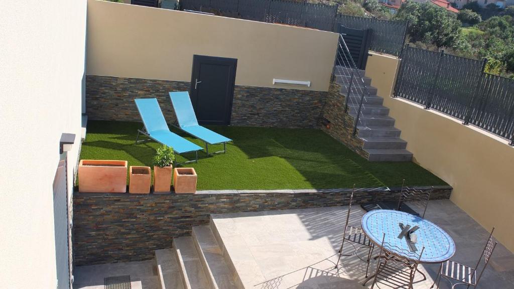 - un balcon avec deux chaises bleues et une table dans l'établissement Entre Banyuls et Collioure T2 à Port vendres, à Port-Vendres
