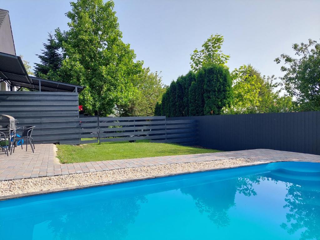 a backyard with a swimming pool and a fence at Silver Gold Anka in Fonyód