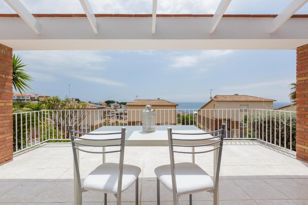 a patio with a table and chairs on a balcony at Villa Grau in Canet de Mar