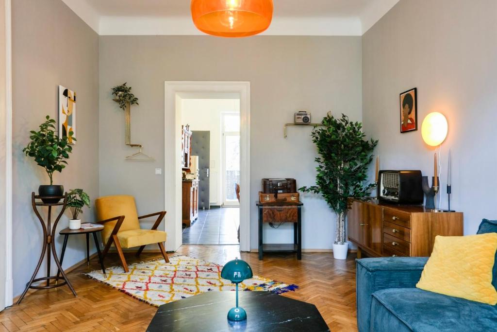 a living room with a blue couch and a table at Kunstvolles Apartment im Zentrum mit Balkon und Parkplatz in Graz
