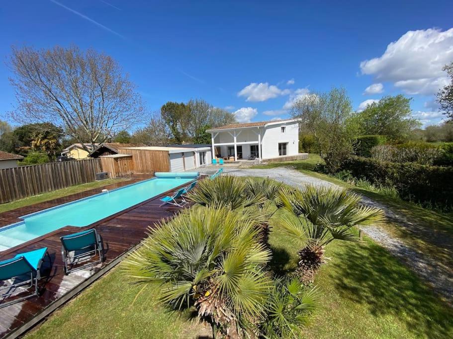 une cour arrière avec une piscine et une maison dans l'établissement Villa Giulianna le Teich bassin d Arcachon, au Teich