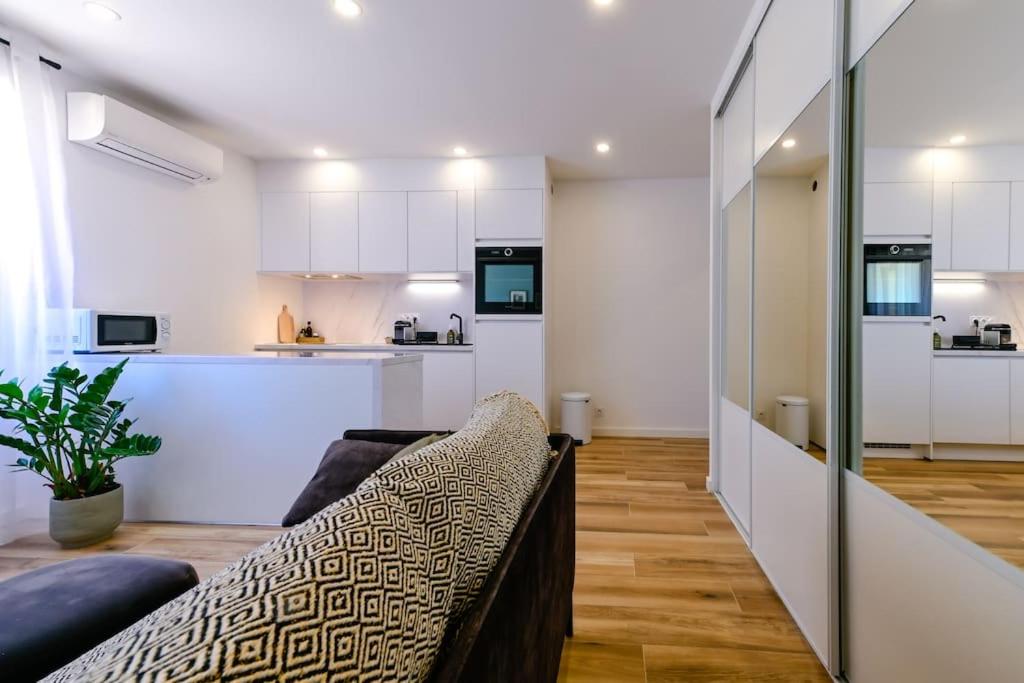 un salon avec un canapé et une cuisine dans l'établissement Studio Cosy à Ajaccio, à Ajaccio