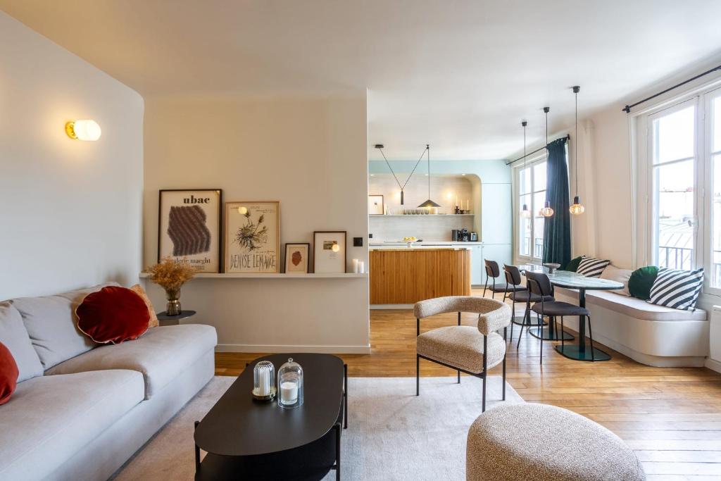 un salon avec un canapé et une table dans l'établissement Habitat Parisien - Madeleine Galeries Lafayette, à Paris