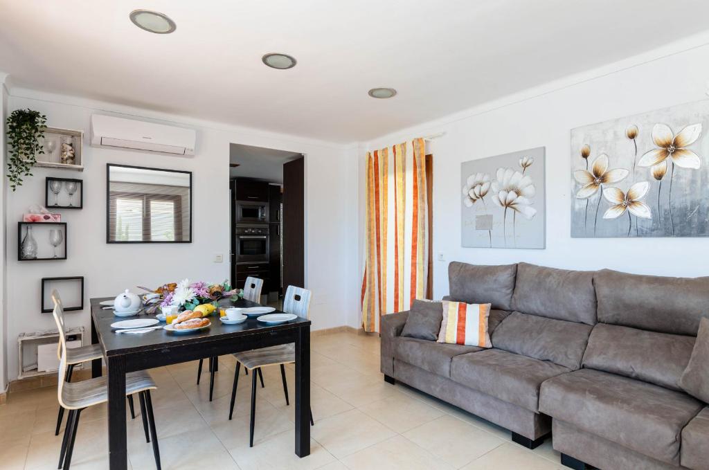 una sala de estar con un sofá y una mesa en YourHouse Reganyol beach apartment, en Puerto de Alcudia