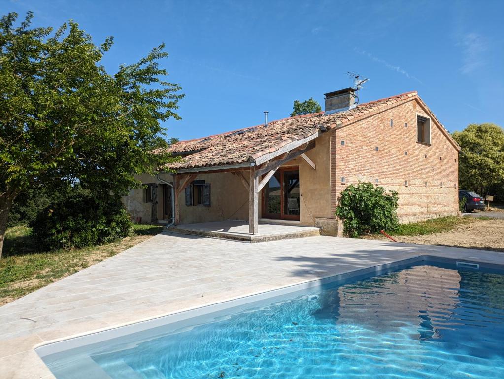 une maison avec une piscine devant une maison dans l'établissement Gite Mondurausse - avec piscine et vue sur la vallée, à La Salvetat-Belmontet