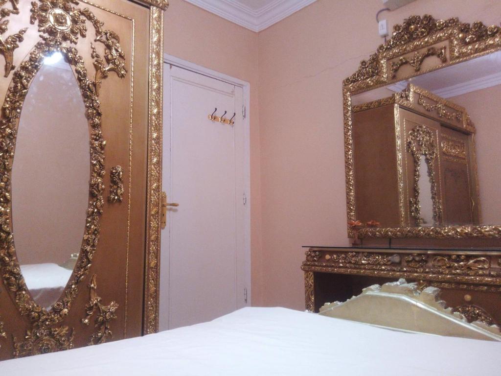 a bedroom with a gold mirror and a fireplace at شقة غرفتين in Sheikh Zayed
