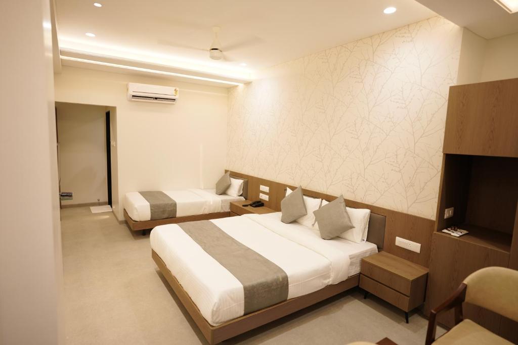 Postel nebo postele na pokoji v ubytování A Square Executive Hotel
