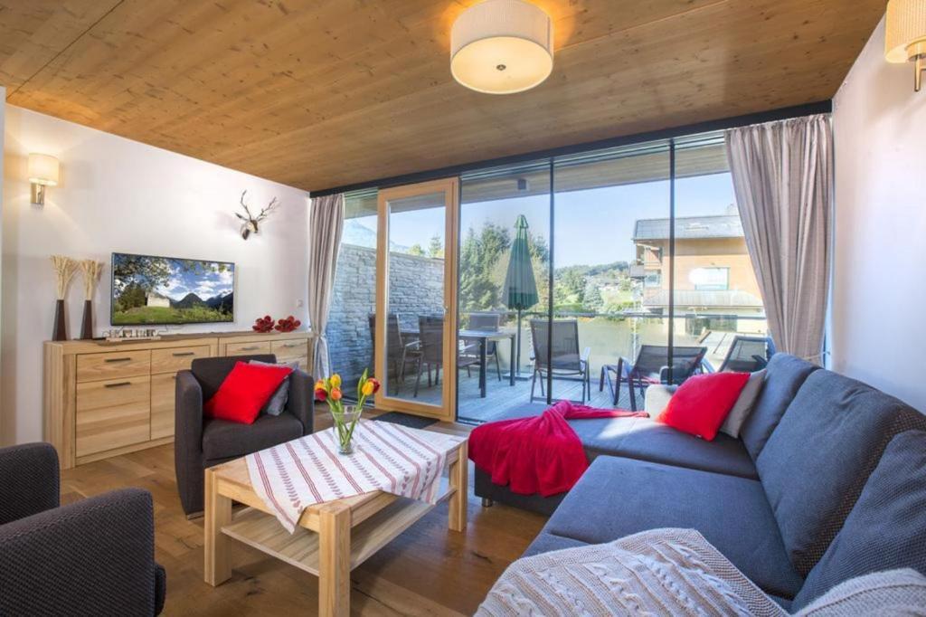 a living room with a blue couch and red pillows at Residenz Wildkogelbahnen Top 11 in Neukirchen am Großvenediger