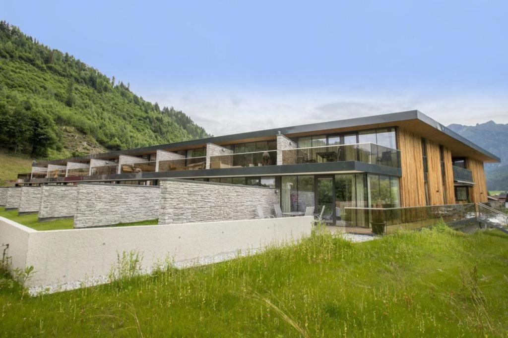 a house on the side of a hill with grass at Residenz Wildkogelbahnen Top 9 in Neukirchen am Großvenediger
