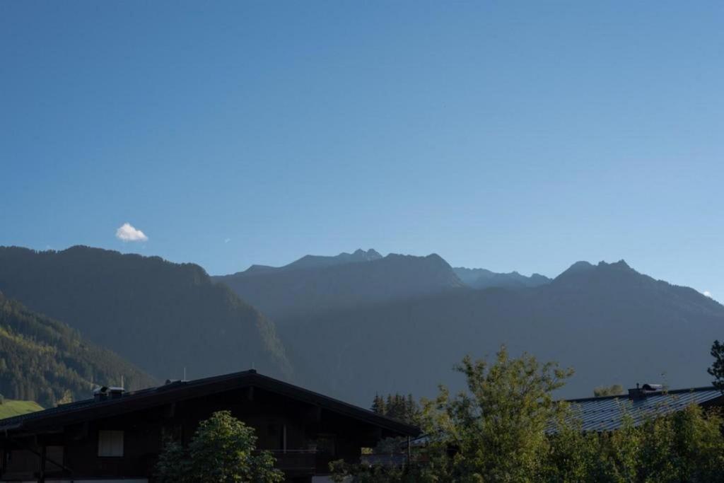 a house with mountains in the background at Residenz Wildkogelbahnen Top 12 in Neukirchen am Großvenediger