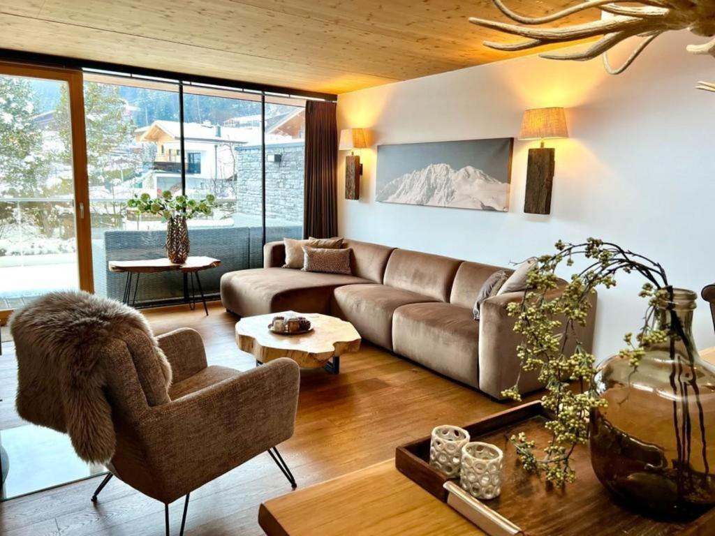 a living room with a couch and a chair at Residenz Wildkogelbahnen Top 17 in Neukirchen am Großvenediger