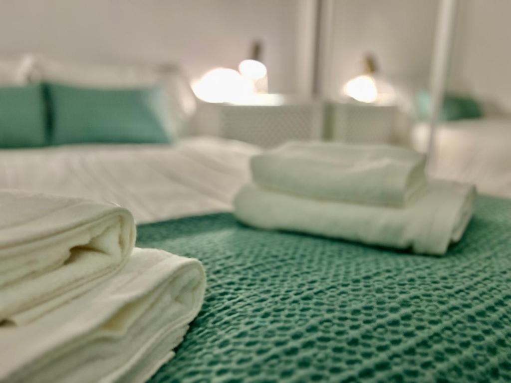a pile of white sheets sitting on a green carpet at Balnea Baiona in Baiona