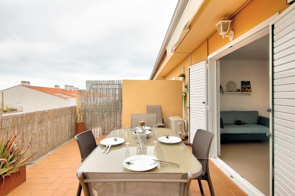 a patio with a table and chairs on a balcony at Atic Els Pins in L'Estartit