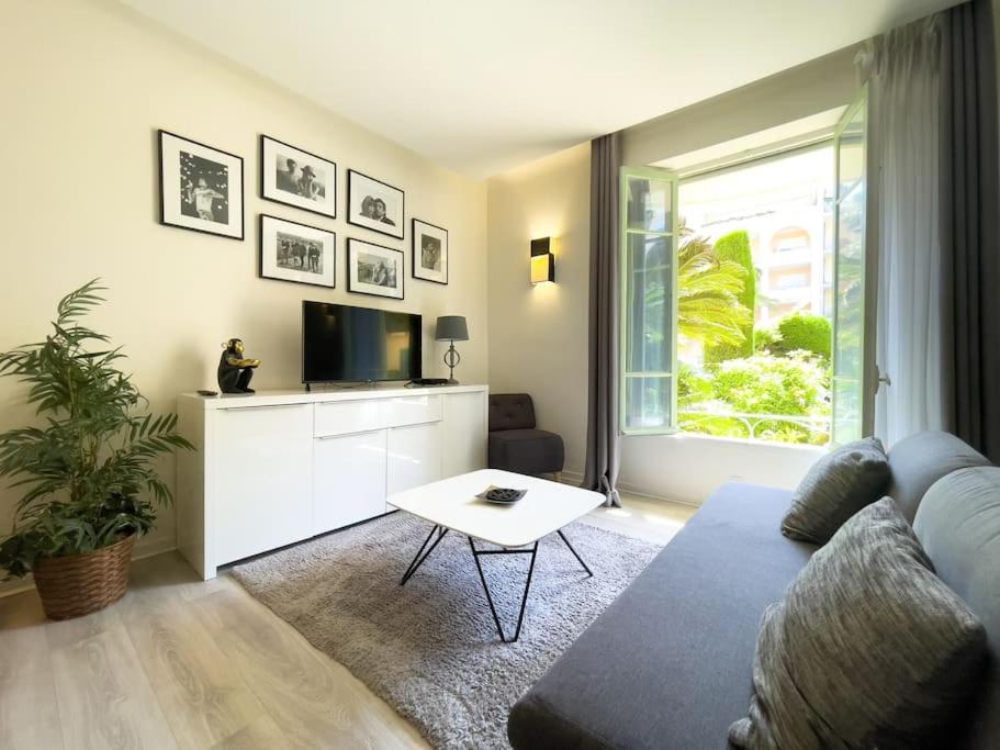 un salon avec un canapé, une télévision et une table dans l'établissement Moderne, calme et bien équipé, à 200m de la plage, à Cannes