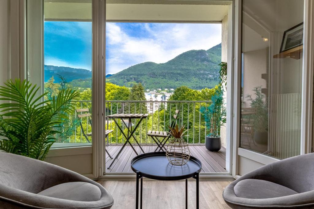 une chambre avec deux chaises, une table et une grande fenêtre dans l'établissement Mont-Lac - Free parking - By a park - Mountain view - near lake, à Annecy