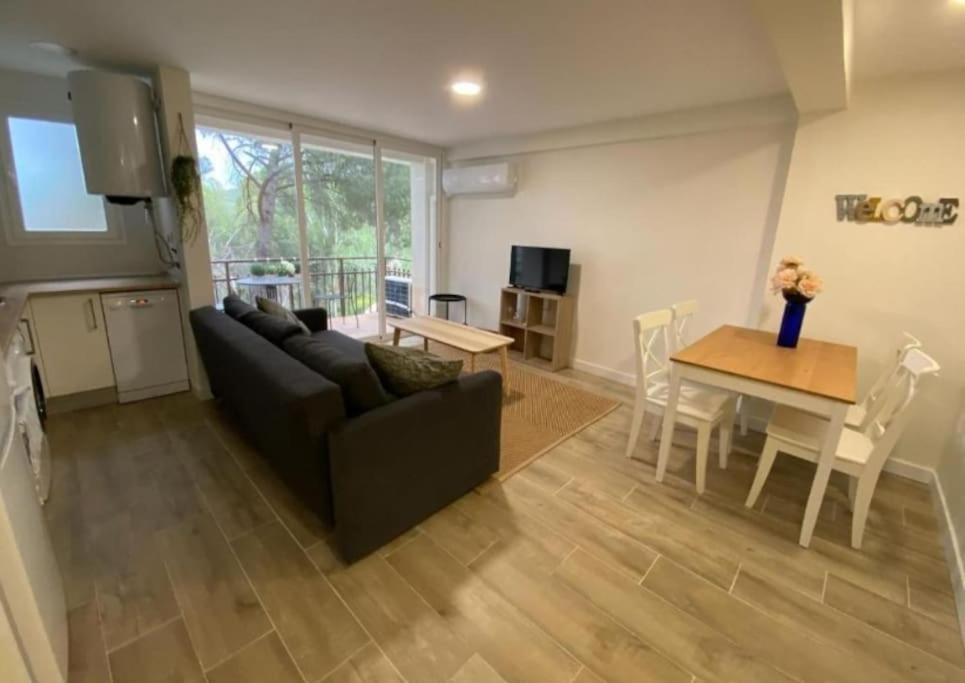 ein Wohnzimmer mit Sofa und Tisch in der Unterkunft Apartment at the foot of Pantano San Juan - 12 in Madrid