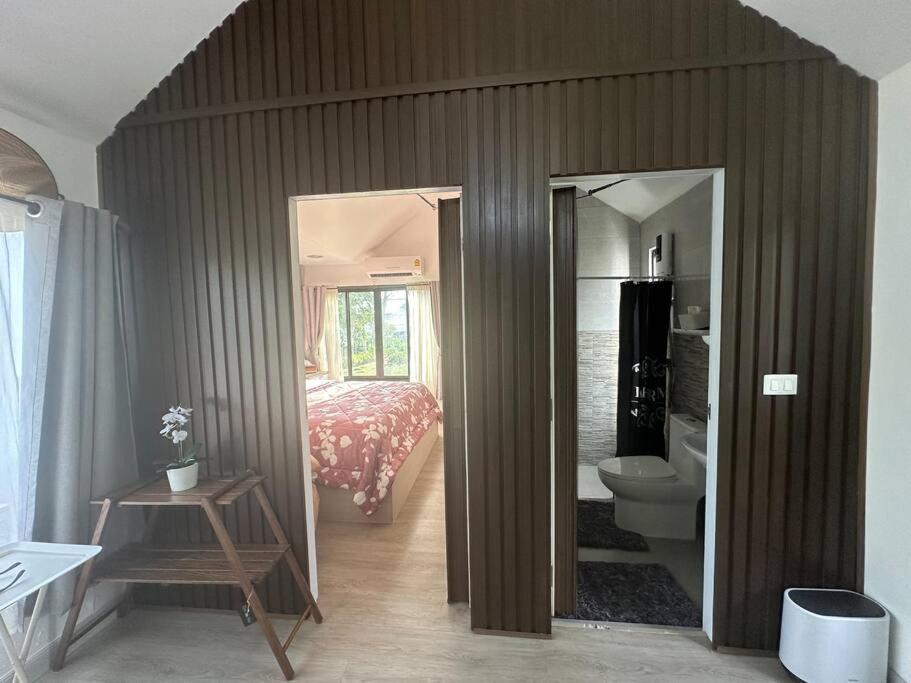 Una habitación con un dormitorio con una cama y un espejo. en Tiny home by the River in Thailand, en Phra Nakhon Si Ayutthaya