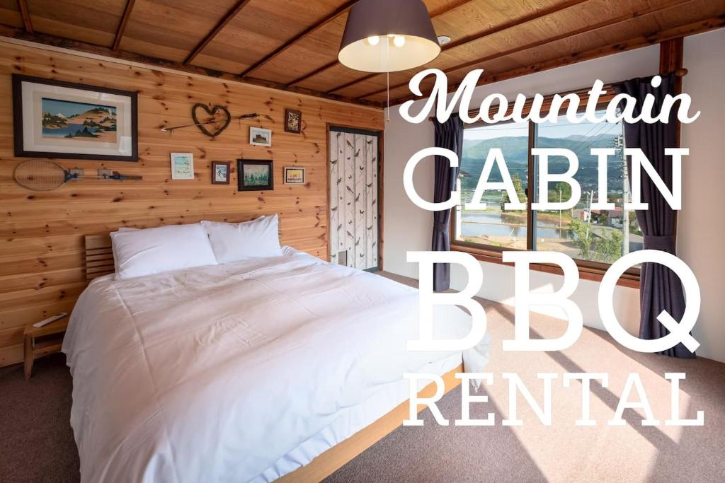 a bedroom with a large white bed in a room at Togari Cottage 2ldk Vacation Home - Pets Ok in Iiyama
