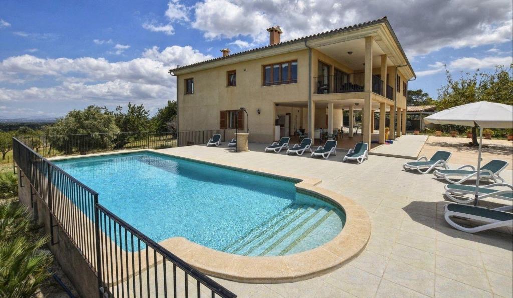 a house with a swimming pool in front of a house at Fantastisches kürzlich gebautes Landhaus mit Panoramablick, Pool und Klimaanlage in Campanet