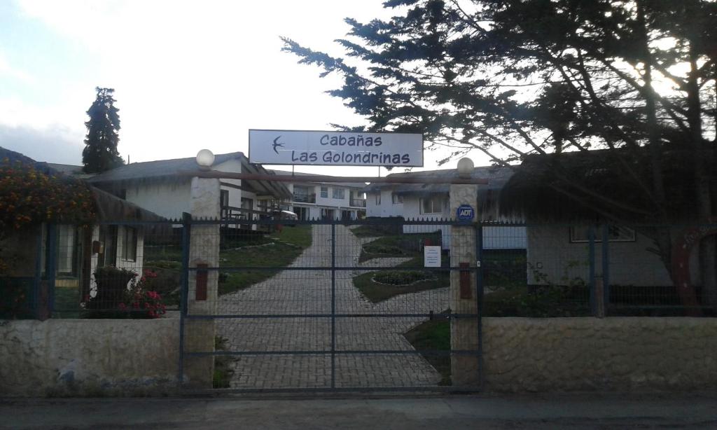 um portão com um sinal em frente a um edifício em Cabañas y Departamentos Las Golondrinas em Coquimbo