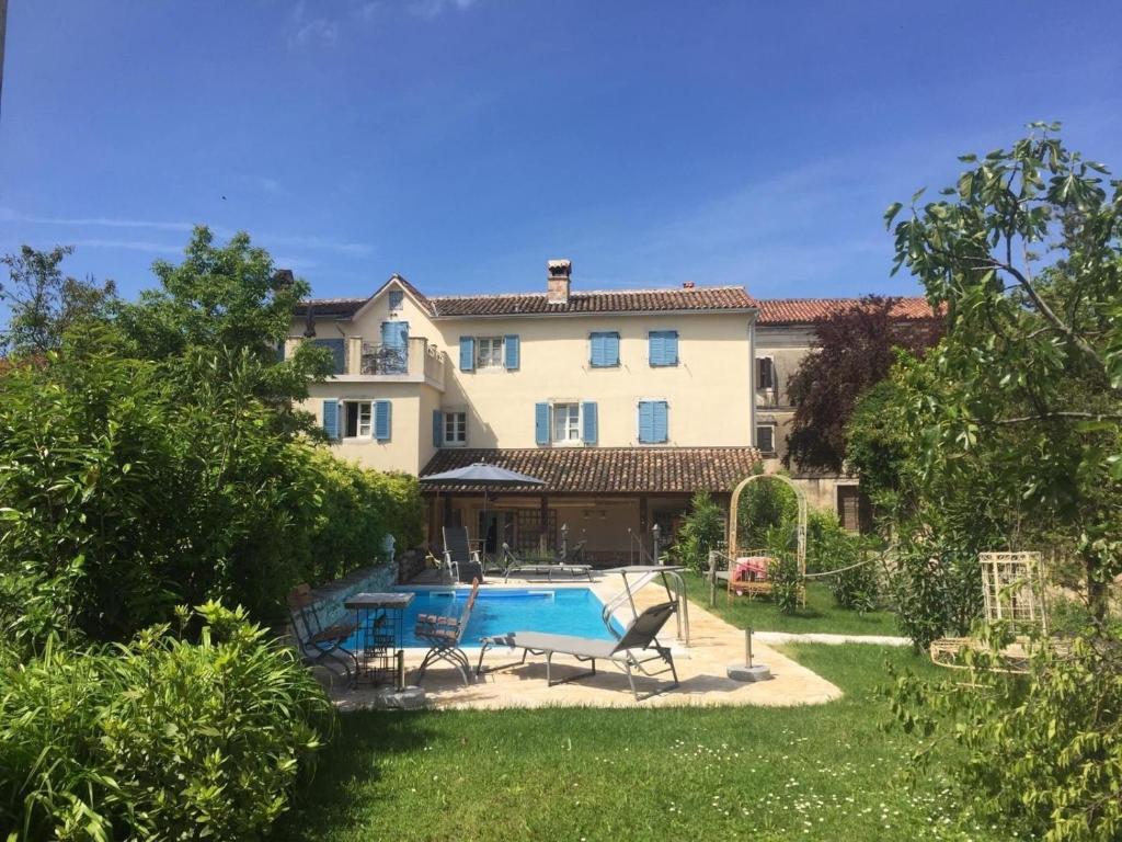 a house with a swimming pool in a yard at Liebevoll eingerichtetes istrisches Steinhaus mit großer überdachter Terrasse in zentraler Lage in Vižinada