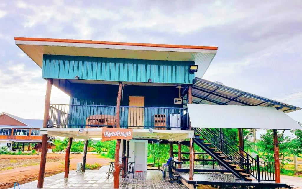 un edificio con il tetto blu e un portico di Jira Hotel เรือนรับรอง a Lampang