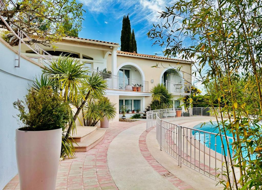 ein Haus mit einem Pool und einem Zaun in der Unterkunft Studio avec loggia, piscine et parking in Montferrier-sur-Lez