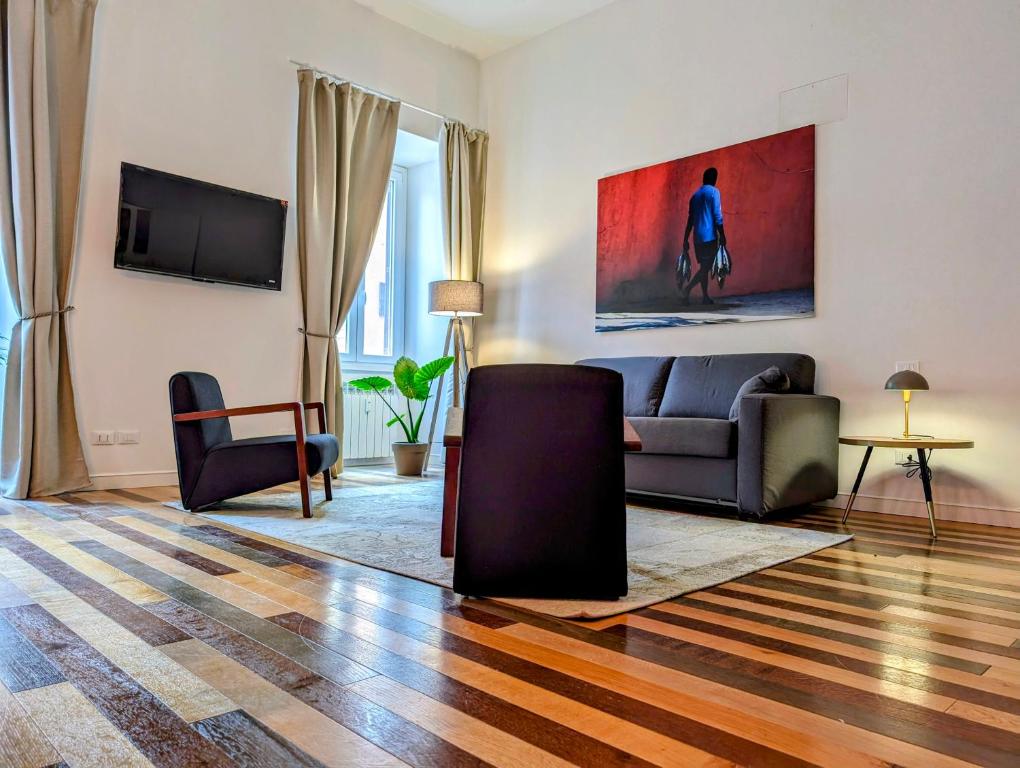 Una sala de estar con un sofá y un televisor en Luxury Gallery Suites, en Roma